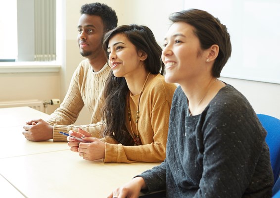 A group of smiling students smiling in a lecture A group of smiling students smiling in a lecture